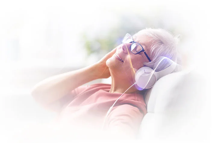 Woman relaxing with headphones during a 12-minute Memory Wave session